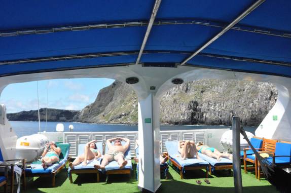 Os russos tomam sol no sun deck do barco, na ilha de Wolf, em Galápagos